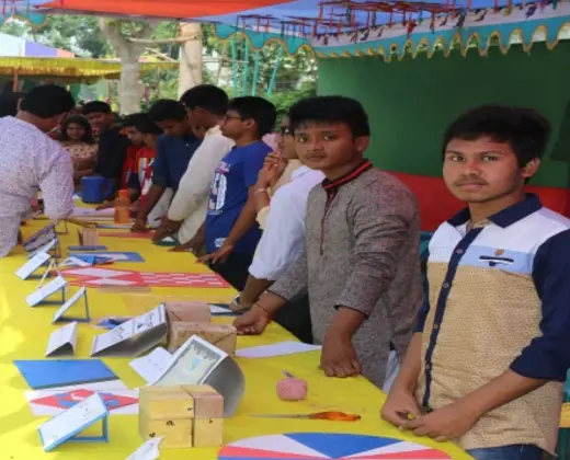 প্রদর্শনী টেবিলের পাশে দাঁড়ানো শিক্ষার্থীরা